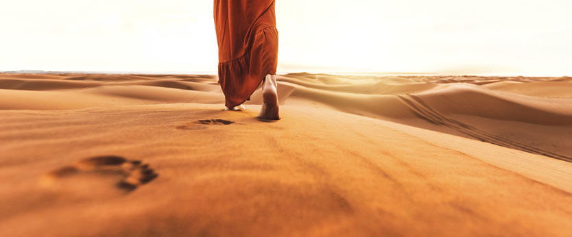 Mujer paseando descalza por el Desierto del Sahara en Marruecos